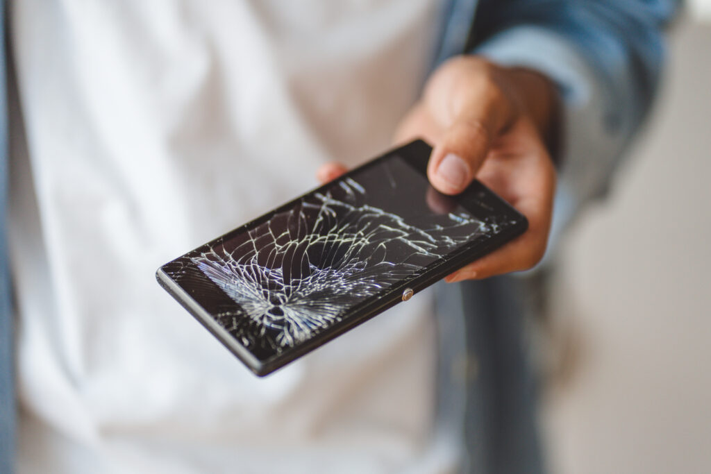 hand-holding-broken-mobile-phone-with-cracked-screen
