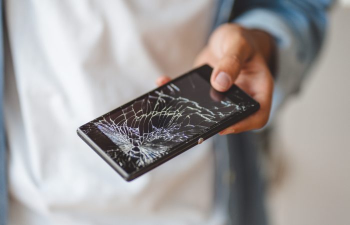 hand-holding-broken-mobile-phone-with-cracked-screen